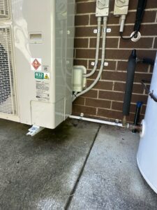 New Panasonic ducted air-conditioning outdoor unit with covered pipework beside a Narrabundah villa.