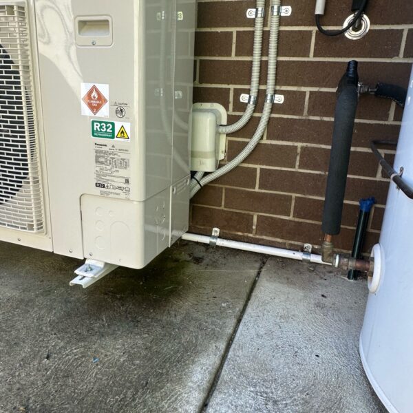 New Panasonic ducted air-conditioning outdoor unit with covered pipework beside a Narrabundah villa.