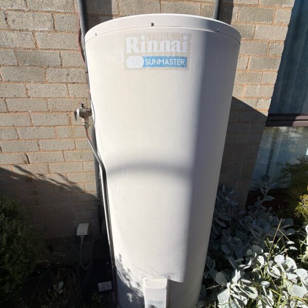 Image: Existing Rinnai Sunmaster solar hot water system serviced during the work at the Chapman home. Rinnai Sunmaster solar hot water storage tank beside a single-storey home in Chapman.