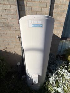 Rinnai Sunmaster solar hot water storage tank beside a large single-storey home in Chapman.