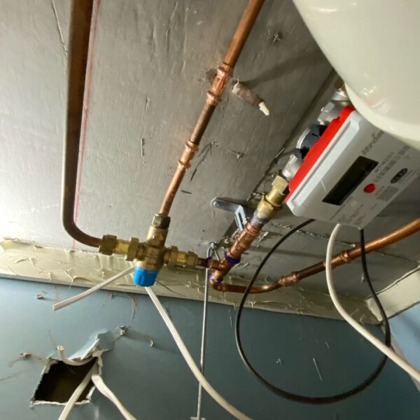 Image: Exposed plumbing connections inspected at a Griffith apartment. Exposed plumbing pipework and fittings inside a two-bedroom apartment in Griffith.
