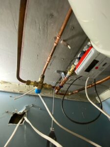 Exposed plumbing pipework and fittings inside a ground-floor apartment in Griffith.