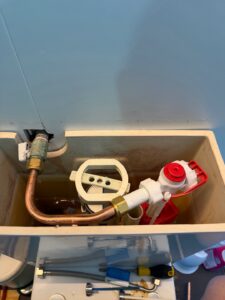 Open toilet cistern with internal parts, replacement components and plumbing tools at an Edinburgh Avenue apartment.